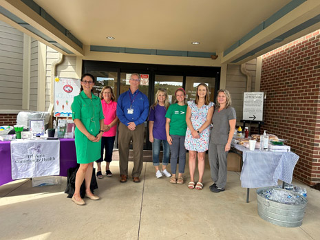 IEA’s RA Leah Suter (left), Tri-Area Community Health CEO Jim Werth (center), and health center staff and providers at community fair in Ferrum, VA