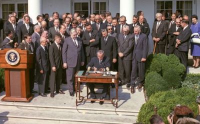 President Lyndon Johnson signs the Economic Opportunity Act.