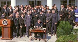 President Lyndon Johnson signs the Economic Opportunity Act.