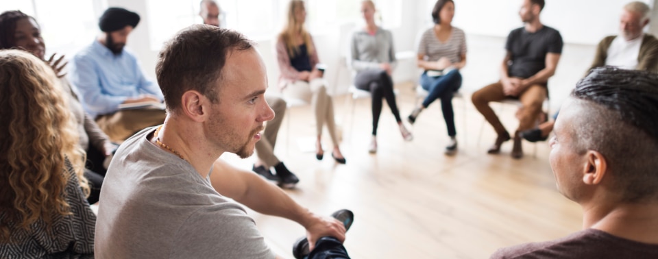 group of people sitting in a circle on chairs