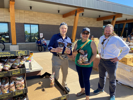HRSA IEA Region 8 RA Nick Zucconi, Regional Director Lily Griego, and Health Center CEO Simon Smith handing out food.